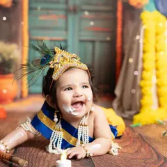 Capturing the playful spirit of a little one in our popular 'Little Krishna' themed photoshoot. This joyful moment, complete with a mischievous, buttery smile, showcases how I bring creative concepts to life for memorable child portraits.