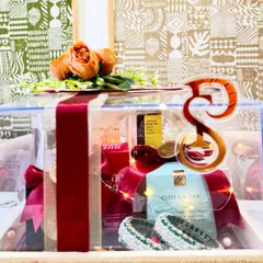 A closer view of the bridal box, showcasing the luxury skincare and makeup products inside. The rich red velvet ribbon adds a classic bridal touch.