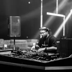 A professional shot of me at the decks during a club night. I'm experienced with the standard club setup, including Pioneer CDJs and mixers, ensuring a smooth performance every time.
