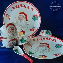 Make mealtime magical with a personalized dining set. This Christmas-themed set includes a plate, bowl, mug, and spoon, all featuring the child's name and a cheerful Santa Claus design. I can create sets in any theme.