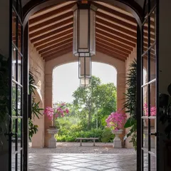 A grand entrance should feel like a welcoming embrace from nature. For this Alibaug villa, I framed the garden view with an archway, creating a living picture that draws you in. The flowering bougainvillea adds a splash of color, promising a serene escape within.