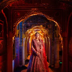 A breathtaking bridal portrait of Niharika in the intricately designed corridors of the palace. I used a mix of red and blue lighting to complement her lehenga and create a dramatic, painterly effect.