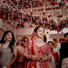 The bride's radiant smile as she enters under the 'phoolon ki chadar'. This is a classic, emotional moment, and we capture her happiness as she walks towards her new beginning.