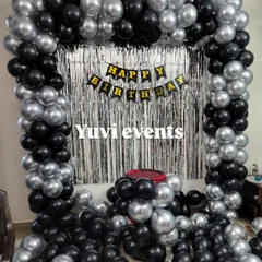 A simple and stylish black and silver balloon arch with a silver foil curtain. This is a great option for a modern birthday party at home.