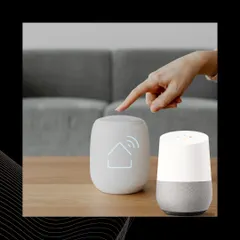 A user interacts with a Google Home device, demonstrating the simple touch and voice interface for smart home control.