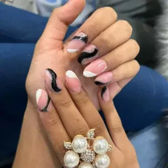 For a modern and chic look, I designed this abstract nail art using a soft pink base with bold black and white waves, accented with a hint of black glitter. This style is done on durable acrylic extensions, perfect for making a statement.
