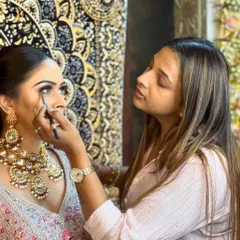 A candid shot of our instructor focused on creating the perfect eye makeup. This reflects our dedication to teaching and achieving perfection in every detail.