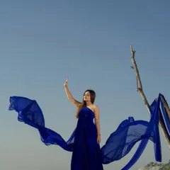 This royal blue flying gown creates a stunning wing-like effect, perfect for dramatic photoshoots in unique locations.