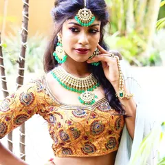 A close-up of a heavily embroidered blouse with intricate patterns. This kind of detailed work makes for a perfect statement piece to be paired with a saree or lehenga for a grand wedding look.