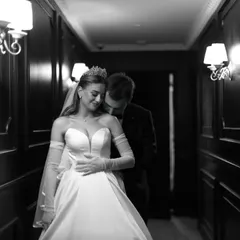 An intimate moment in a quiet hallway. This black and white portrait captures the tender connection between a bride and groom, a silent promise of the lifetime ahead.