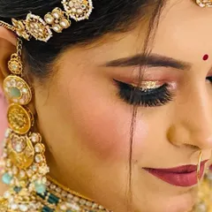 A detailed shot of this bride's eye makeup, featuring a beautiful gold shimmer on the lid and a deep matte lip color.