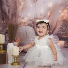 A pure, joyful laugh from a little girl in a beautiful white dress, set against a dreamy, boho-chic backdrop with soft lights.