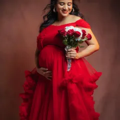 Embrace the power and beauty of motherhood in this stunning red off-shoulder ruffle gown. The vibrant color and soft texture make it a popular choice for clients who want bold, memorable photos.