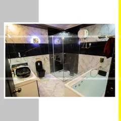 The master bathroom at Rock Villa, featuring a modern bathtub, a glass-enclosed shower, and a contrast of black and white marble-patterned tiles. This space was designed to provide a spa-like, luxurious experience.