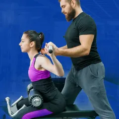 Perfecting your form is my top priority. Here, I'm guiding a client through a back exercise, ensuring her posture is correct to prevent injury and maximize muscle engagement.