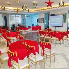 We transform indoor spaces for corporate functions, like this Christmas event at the BPTP Amstoria sales office. The setup includes festive red-themed table arrangements, formal seating, and a projector screen, making the space suitable for both celebration and presentations.