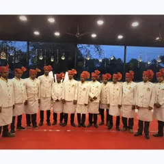 Our staff dressed in traditional attire with orange turbans, perfect for adding an authentic touch to a wedding or cultural celebration.