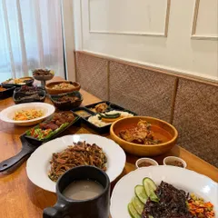 A New Year's feast spread across the table. This is how we celebrate, with an abundance of dishes like pork ribs, noodles, curries, and rice, meant to be shared with family and friends.