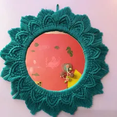 A beautiful sunburst-style macrame mirror in a rich teal color. This design adds a pop of color and a touch of bohemian elegance, perfect for an entryway or bedroom.
