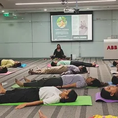 Leading a large group of employees at ABB through a deep relaxation exercise. Providing these moments of rest in a corporate setting is essential for preventing burnout and enhancing productivity.