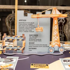 A custom-designed menu holder in the shape of a crane adds a playful yet functional detail to the construction party table.