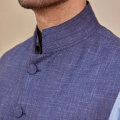 A close-up of the textured fabric and mandarin collar of the navy Nehru vest. The craftsmanship and detail are what give this classic piece its modern, refined edge.