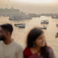 An artistic shot using a shallow depth of field, with the couple out of focus and the serene harbor as the subject. This composition suggests a shared, private world against a beautiful backdrop.