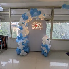 A wider view of the blue and white balloon arch against a clean white backdrop, suitable for halls and indoor venues.