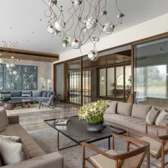 The expansive living room of the K Residence, designed to be both a grand space for entertaining and an intimate family area. The design incorporates large sliding doors to flood the room with natural light and features custom furniture and curated art, including exquisite Bocci lights.
