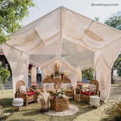 A serene welcome under woven dreams. We styled this bohemian mehendi lunch with a large macrame canopy, earthy-toned cane furniture, and curated pampas arrangements for a touch of organic elegance.
