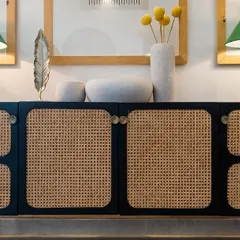 Cane furniture is making a comeback for good reason. This beautiful black and cane side cabinet adds texture, warmth, and a touch of timeless luxury to this living room.