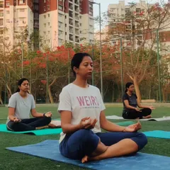 Participants practicing seated meditation and pranayama outdoors during a retreat. Connecting with the breath while surrounded by fresh air and greenery deepens the sense of calm and grounding.