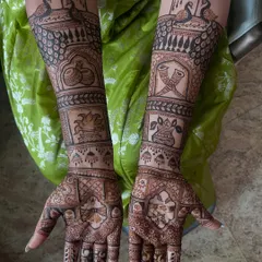 This custom bridal henna features a story told through different elements on each arm, including peacocks, kalash, and dholki motifs, all woven together with classic patterns.
