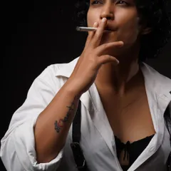 A close-up from the same conceptual series. This shot focuses on the subject's expression and the subtle details of the smoke and styling.