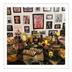 We create a feast that complements your home's warmth. This grazing table is set against a beautiful gallery wall, blending seamlessly into the party's atmosphere with an array of tacos, dips, and fresh fruits.