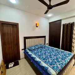 A wider view of the bedroom, showing the placement of the bed, wardrobe, and the matching wooden door, creating a harmonious look.