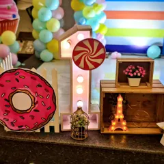 A close-up of the details from the candyland theme, including a light-up number '1' with a lollipop accent and a giant donut prop.