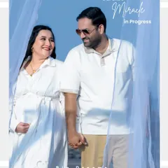 A happy couple holding hands during their outdoor maternity session. The bright blue sky and light, airy outfits give this portrait a fresh and joyful feel.