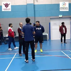 A group of adult players listening intently to the coach's insights at our international center in Qatar.
