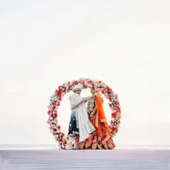 A unique and artistic Varmala ceremony setup in Goa. The circular floral arch perfectly frames the couple against the vastness of the sea, creating a powerful symbol of their union.