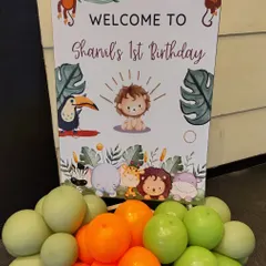 Welcome your guests to a wild adventure with our jungle-themed first birthday decor. This welcome sign, featuring adorable safari animals and a garland of green and orange balloons, is the perfect way to introduce your party's theme right from the entrance.