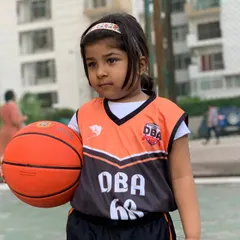 The journey begins with a single dribble. A young player in her DBA jersey, ready to learn and play.