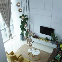 An aerial view of the penthouse living area, showing how I use a large jute rug to ground the seating arrangement and create a cozy zone within the expansive, open-plan space.