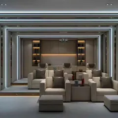 This home theater design uses dramatic, layered portals with LED lighting to create a futuristic entrance effect. The comfortable, tiered seating ensures everyone has a perfect view of the screen.