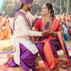 A candid moment from a traditional Maharashtrian wedding ceremony. The bride's makeup is designed to look fresh and radiant even in the bright, outdoor light.