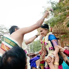 A joyful ritual from a Tamil wedding where the bride and groom are lifted up by their families to exchange garlands.