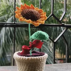 A full view of my crochet potted sunflower. The flower "grows" out of crochet "soil" in a handmade pot, complete with a little green leaf.