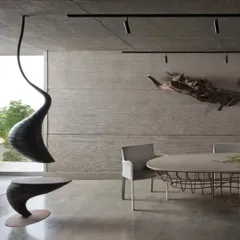 A detail from our studio's meeting area, showcasing custom-designed sculptural furniture against a backdrop of board-formed concrete. The hanging seat and driftwood wall art are functional sculptures that reflect our belief that every element in a space should be a piece of art.
