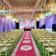 A beautiful banquet setup at a Vashi location, available for just 60k including AC, rent, and decoration. The hanging floral ceiling and green turf flooring create a garden-like feel indoors.