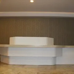 The reception table viewed from another angle, highlighting its asymmetrical design and the interplay of forms. This piece was designed to be visually engaging from all perspectives in the hotel lobby.